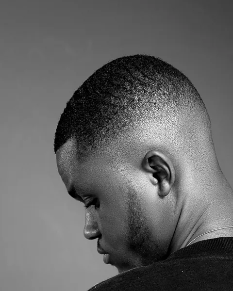 The back and side of a man's head with a low fade.