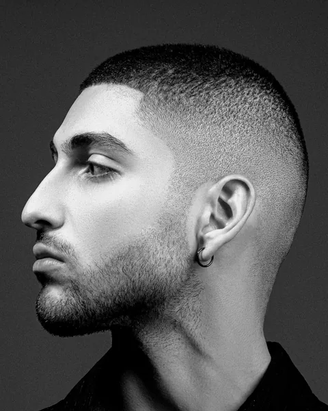 Side view of a man with a short skin fade, the sides taken down to the skin.