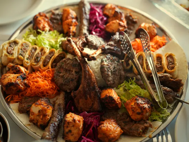 A large mixed grill platter of lamb chops, kofta and chicken with rice and slaw.